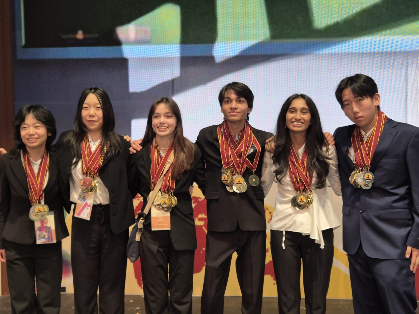 Arthur with his team and their medals, Doha 2025