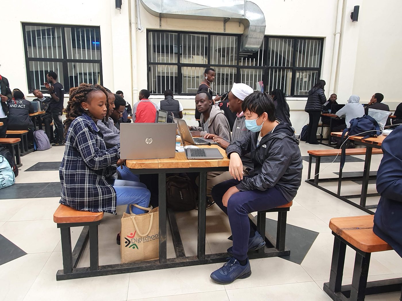 Students working on laptops in a study hall